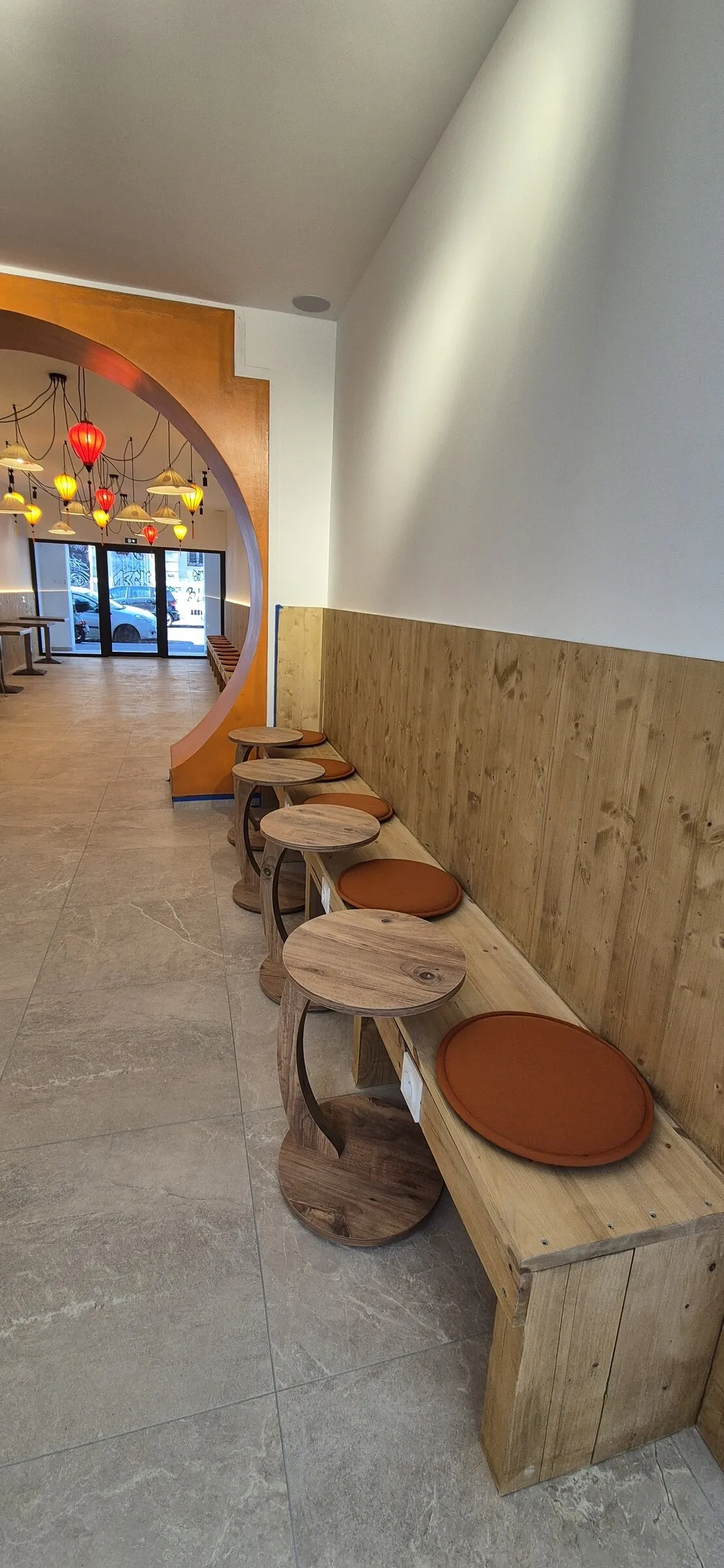 Banquette en bois et tabourets le long du couloir