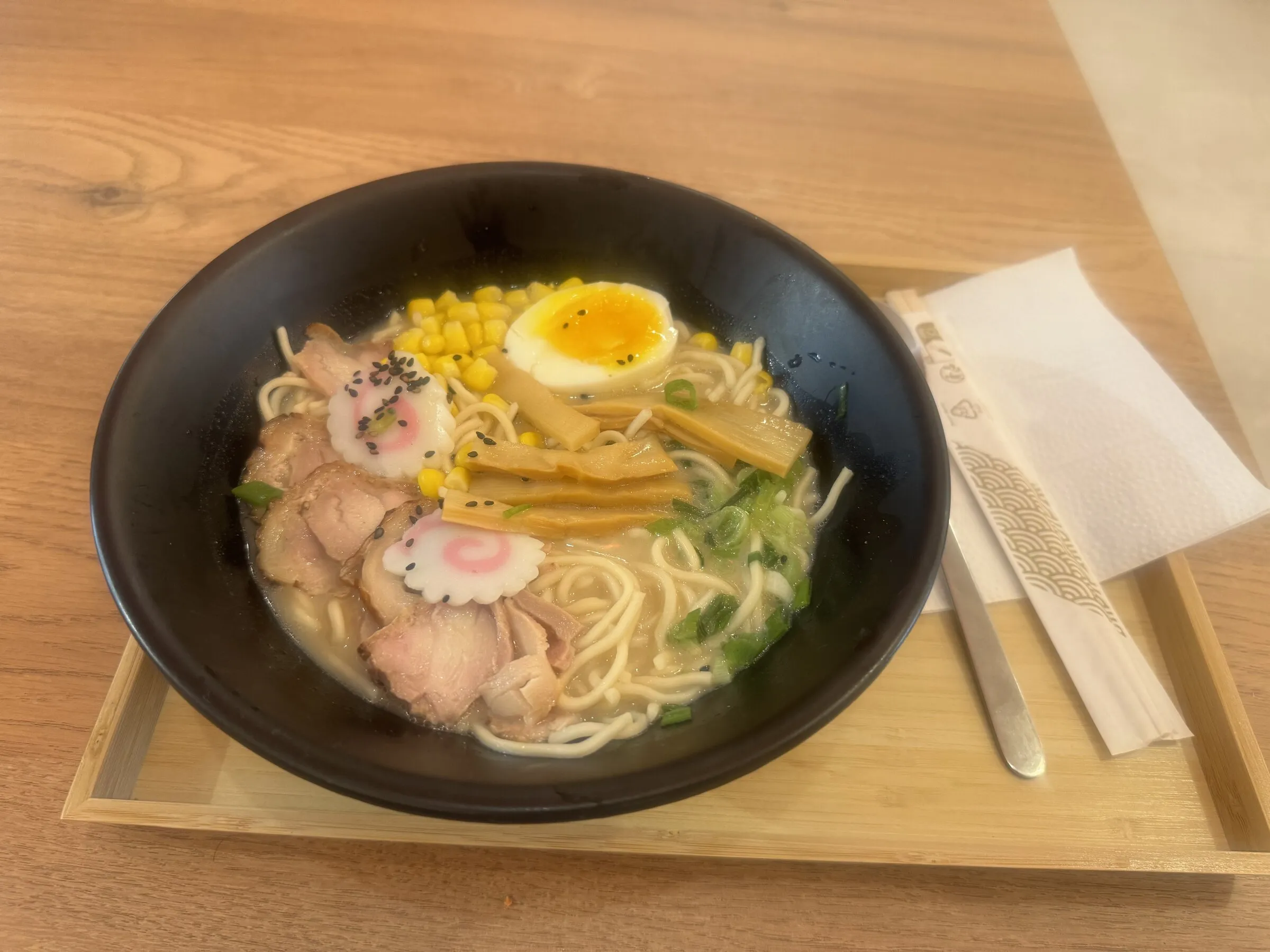 Bol de ramen avec œuf mariné, viande, maïs et pousses de bambou